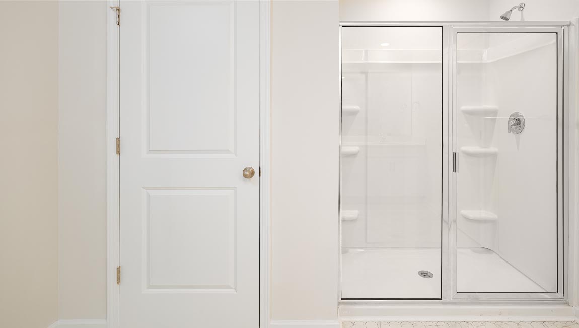 Primary bathroom with double sinks, white cabinets and counters