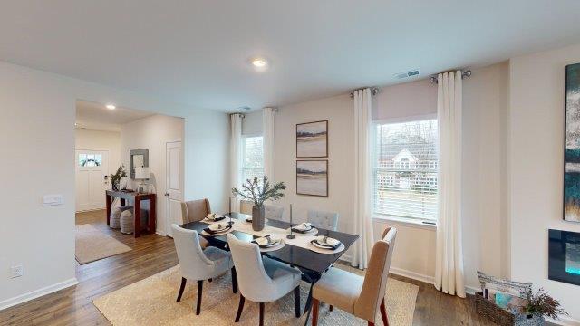 Dining room off of the kitchen featuring a table with chairs and 2 windows on the back wall