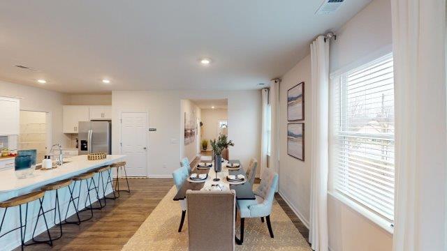 Dining room off of the kitchen featuring a table with chairs and 2 windows on the back wall