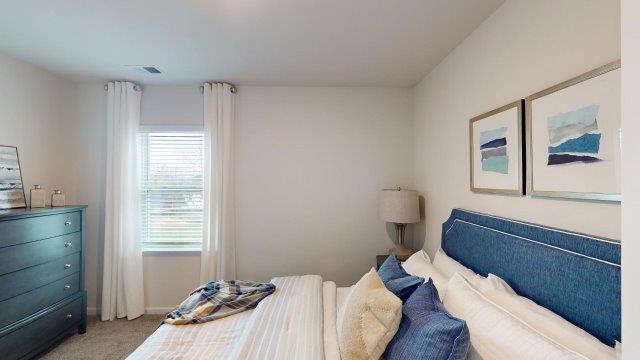 Bedroom featuring a bed, decorated in dark blue tones with a large window