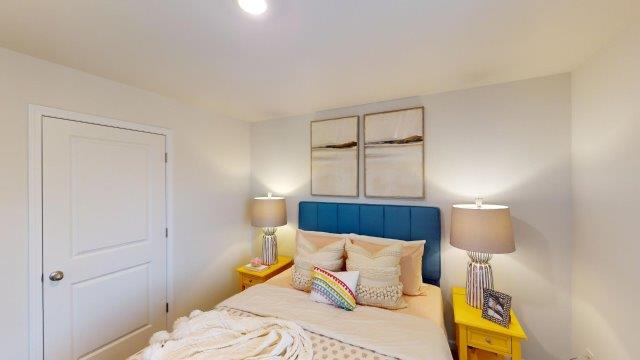 Bedroom featuring a bed, decorated in dark blue tones with a large window