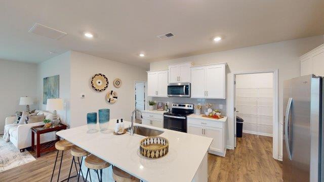 Falls at Hickory Robie Model Kitchen and island, with white counters and cabinets. New Home in Charlotte, North Carolina