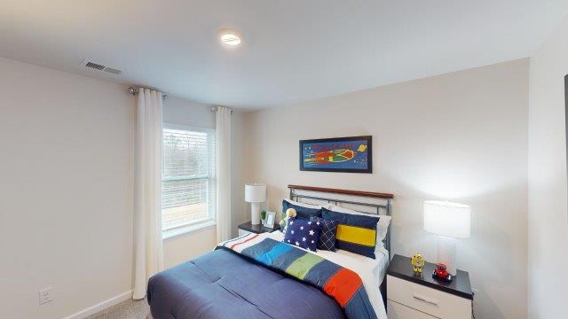 Bedroom featuring a bed, decorated in dark blue tones with a large window