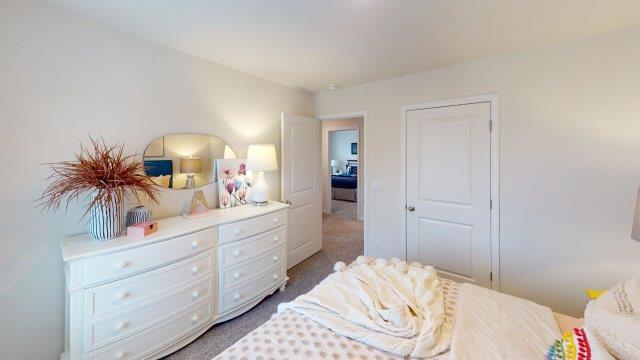 Bedroom featuring a bed, decorated in dark blue tones with a large window