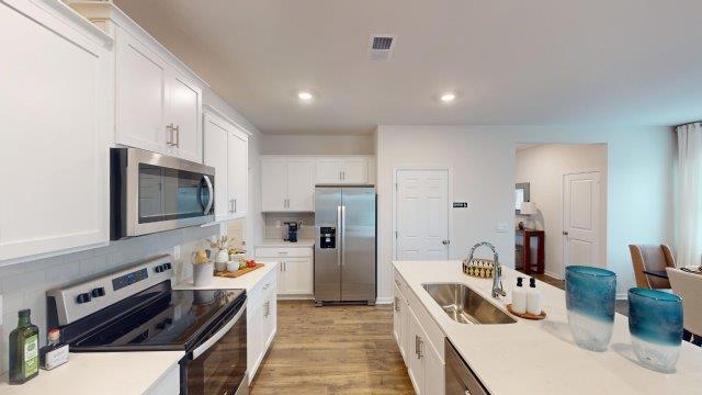 Falls at Hickory Robie Model Kitchen and island, with white counters and cabinets. New Home in Charlotte, North Carolina