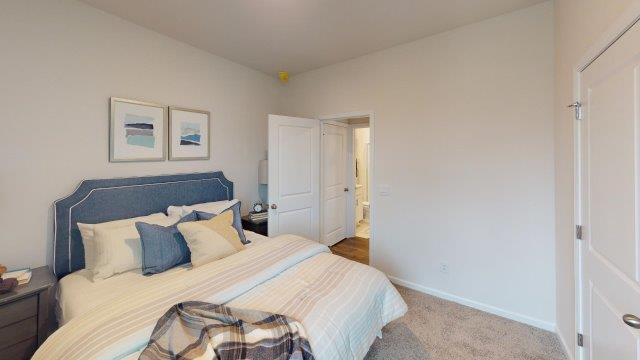 Bedroom featuring a bed, decorated in dark blue tones with a large window