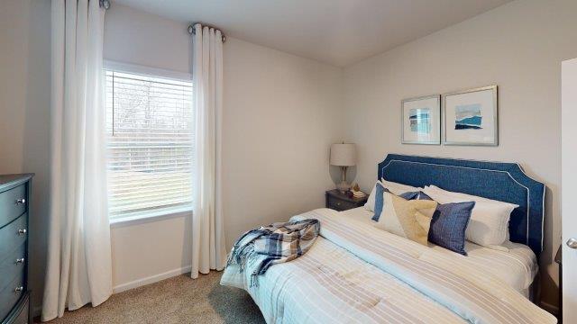 Bedroom featuring a bed, decorated in dark blue tones with a large window