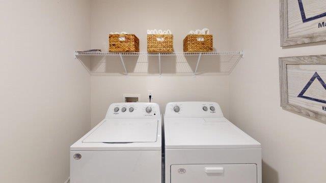 Spacious laundry room featuring side by side washer and dryer