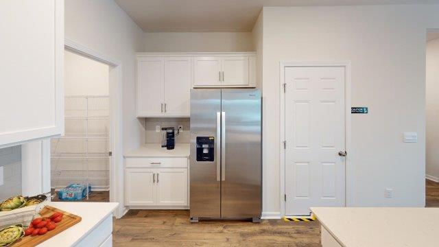 Falls at Hickory Robie Model Kitchen and island, with white counters and cabinets. New Home in Charlotte, North Carolina