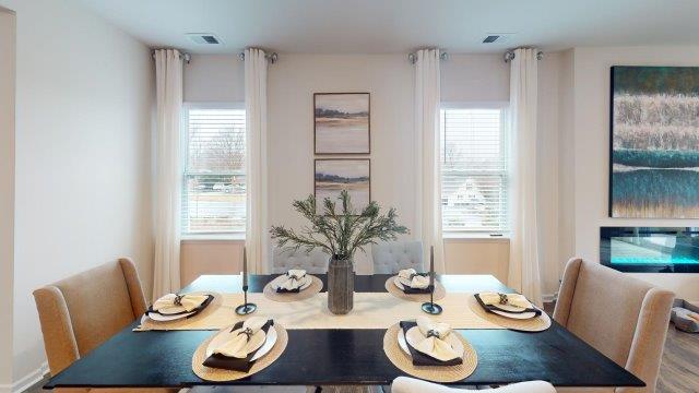 Dining room off of the kitchen featuring a table with chairs and 2 windows on the back wall