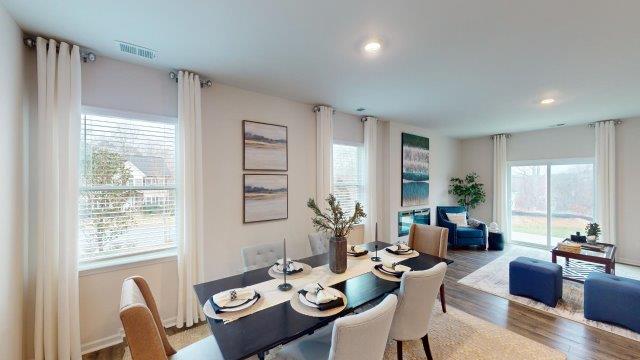 Dining room off of the kitchen featuring a table with chairs and 2 windows on the back wall