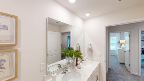 Primary bathroom with white cabinets and counters, and glass door shower