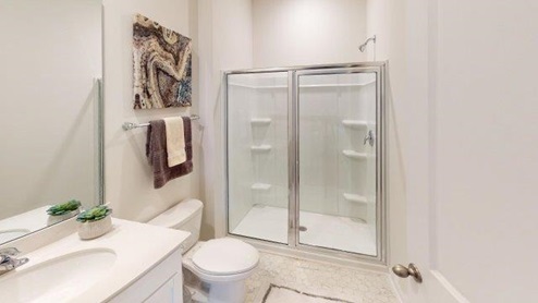 Bathroom  with white cabinets and counters, and glass door standing shower