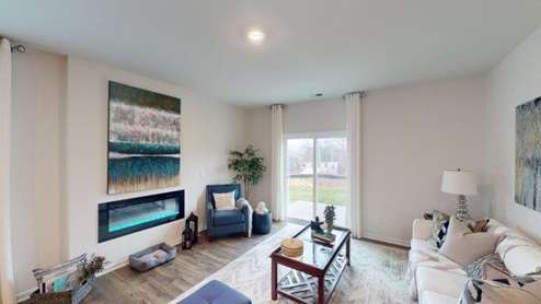 Falls at Hickory Robie Model Living room with large window and electric fireplace. New Home in Charlotte, North Carolina