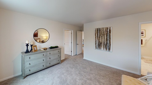 Bedroom featuring a large bed, decorated in neutral tones with 2 windows on the right wall