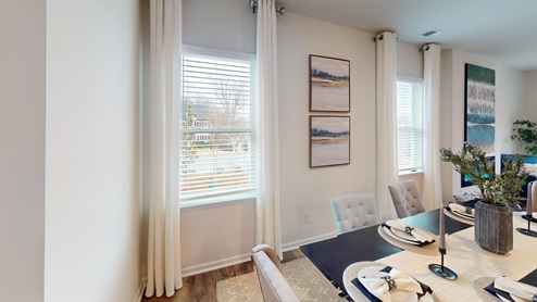 Dining room off of the kitchen featuring a table with chairs and 2 windows on the back wall