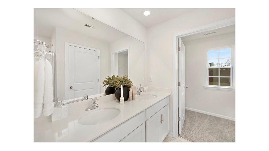Primary bathroom with double vanity and glass door shower