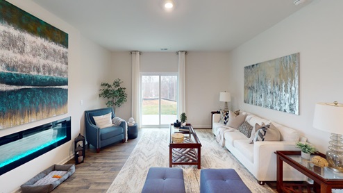 Living room featuring a white sofa, decorated in blue tones with a modern black fireplace
