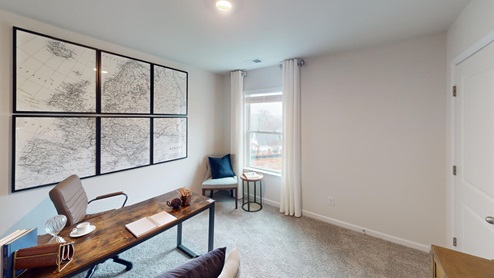 Home office featuring a desk, and a window on the back left corner