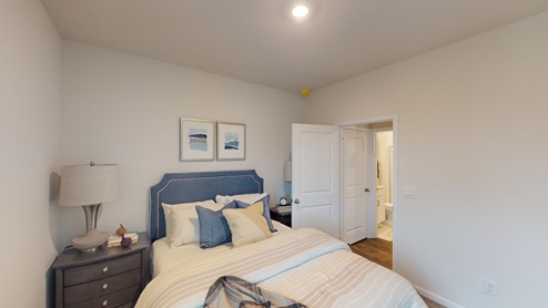 Bedroom featuring a bed with a blue headboard and neutral decor