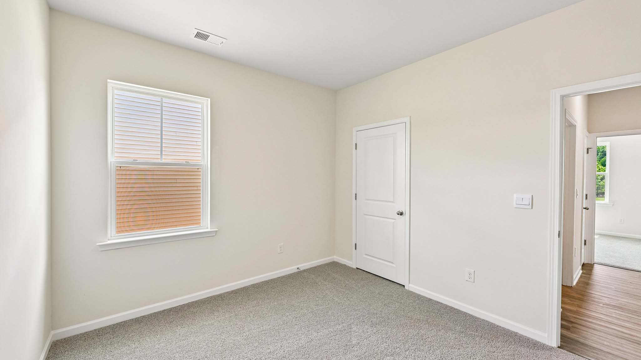 Carpeted bedroom with large window
