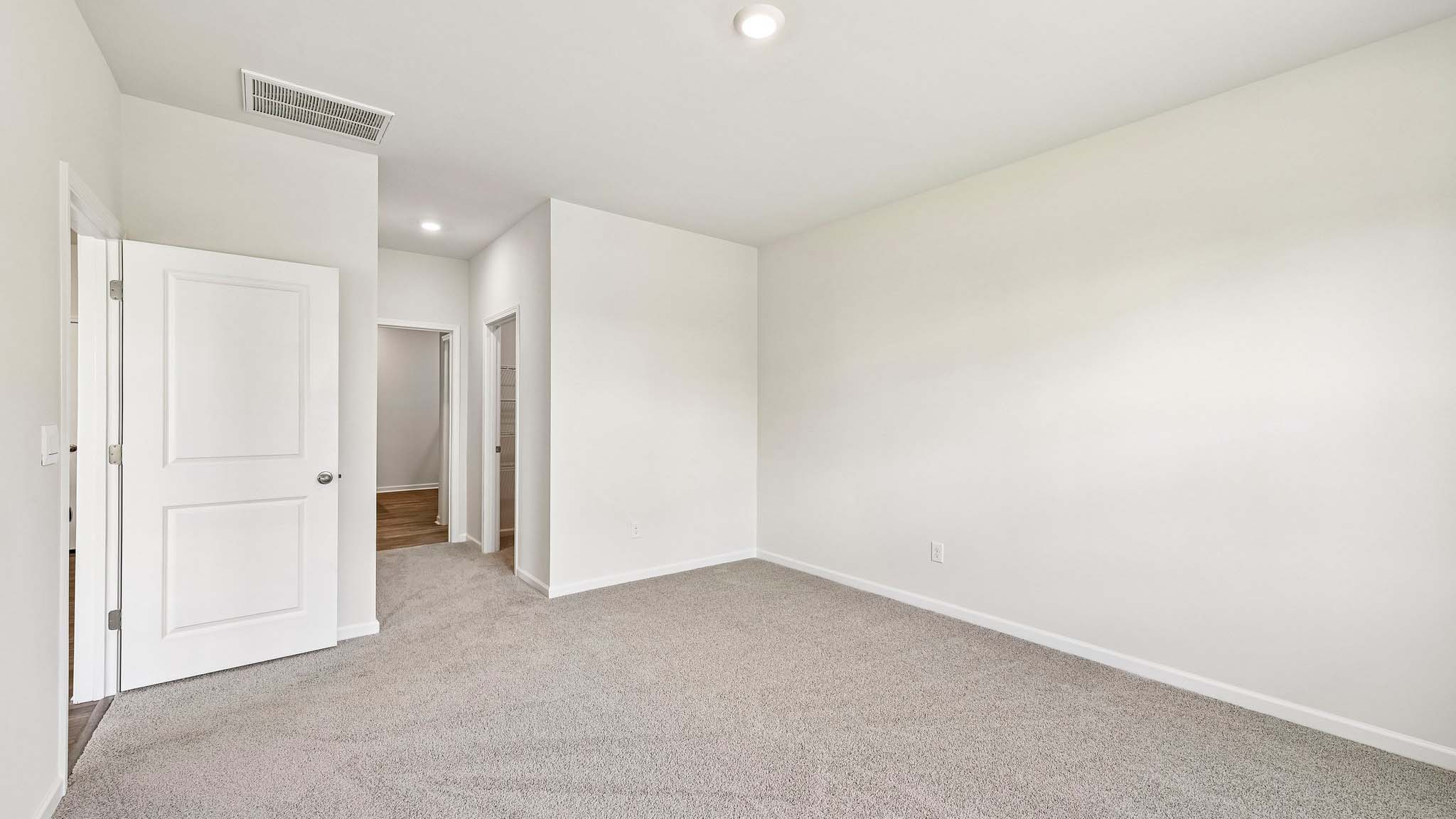 Primary carpeted bedroom with windows