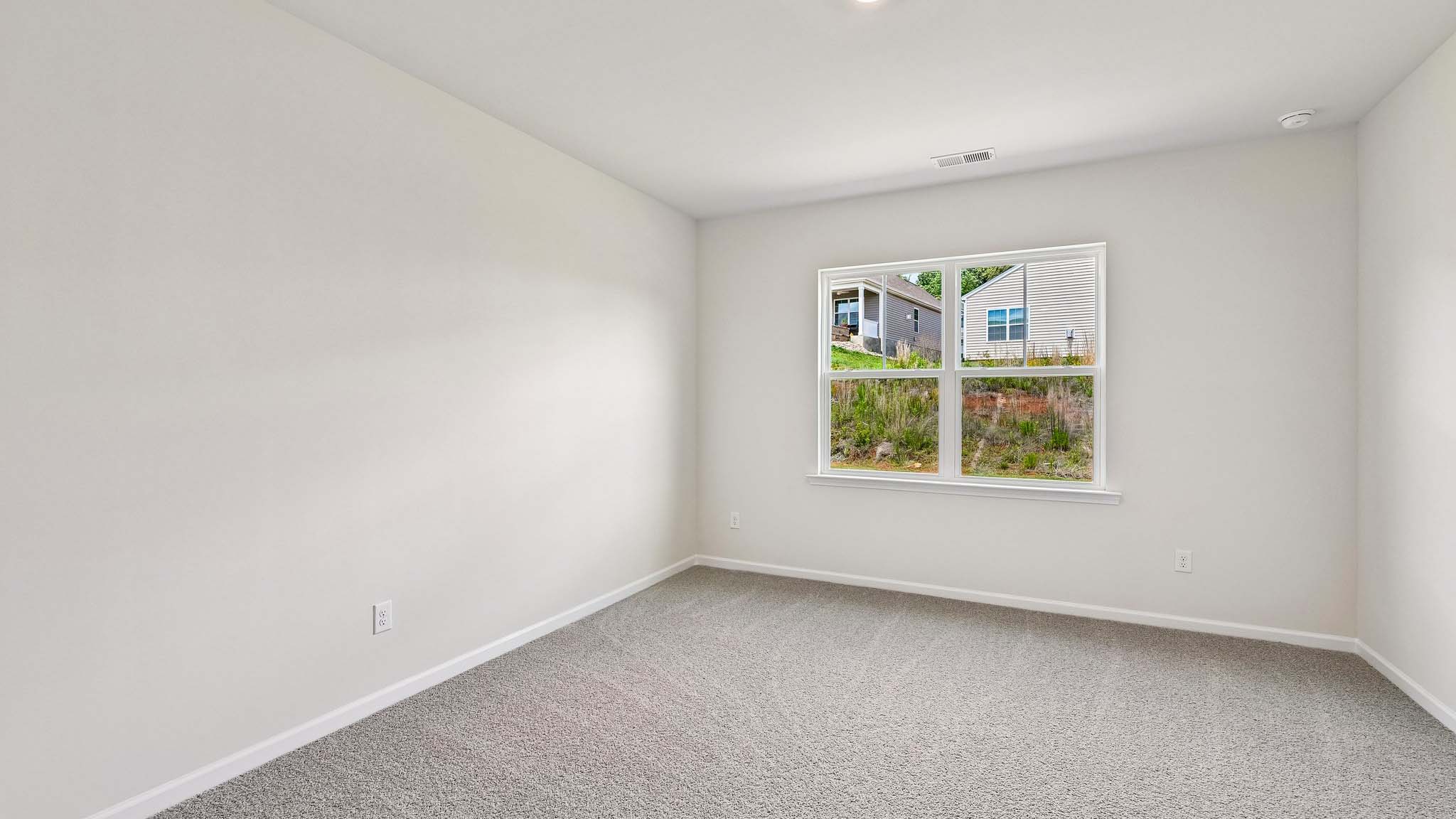 Primary carpeted bedroom with windows