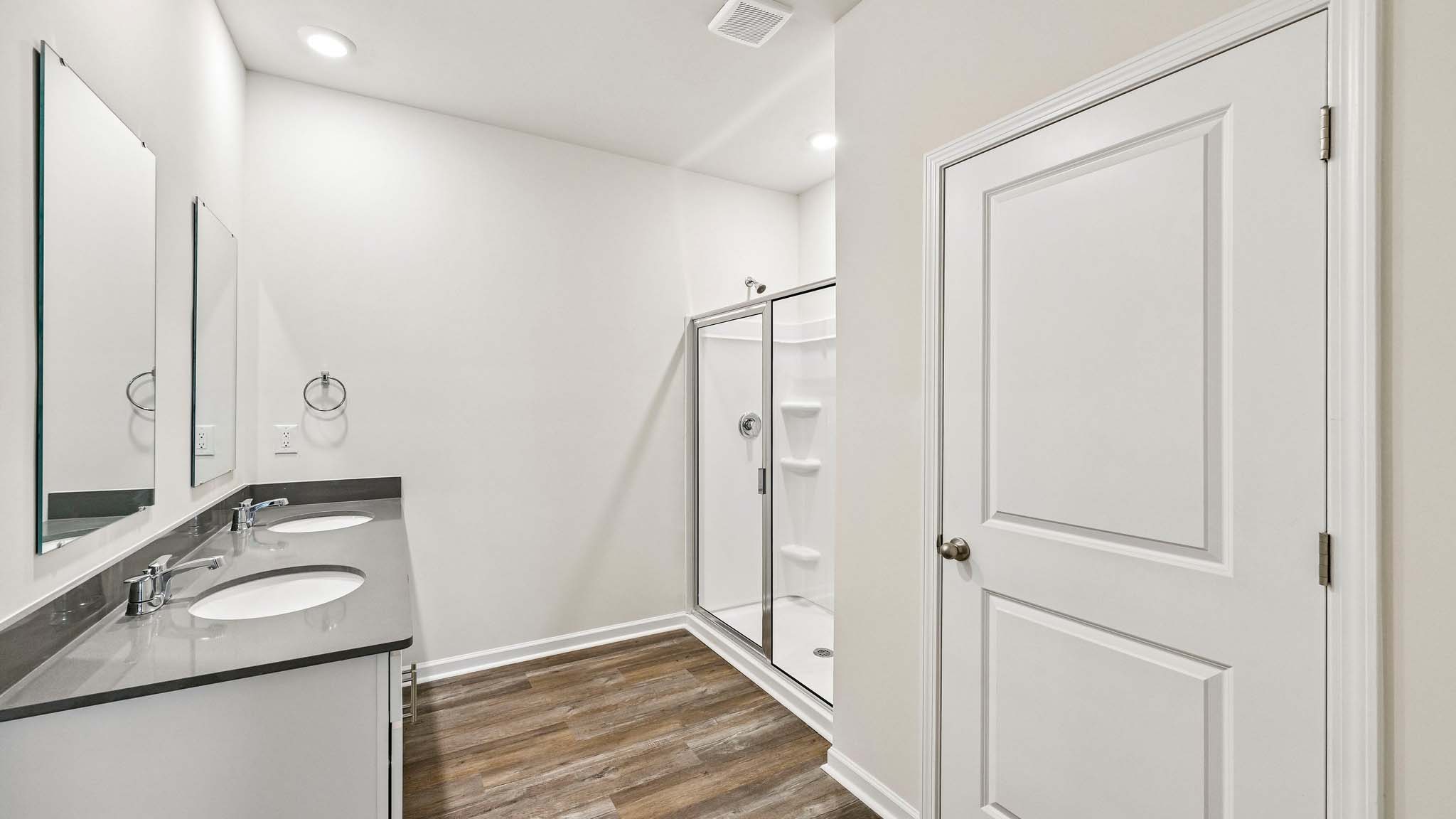 primary bathroom with double sinks and shower