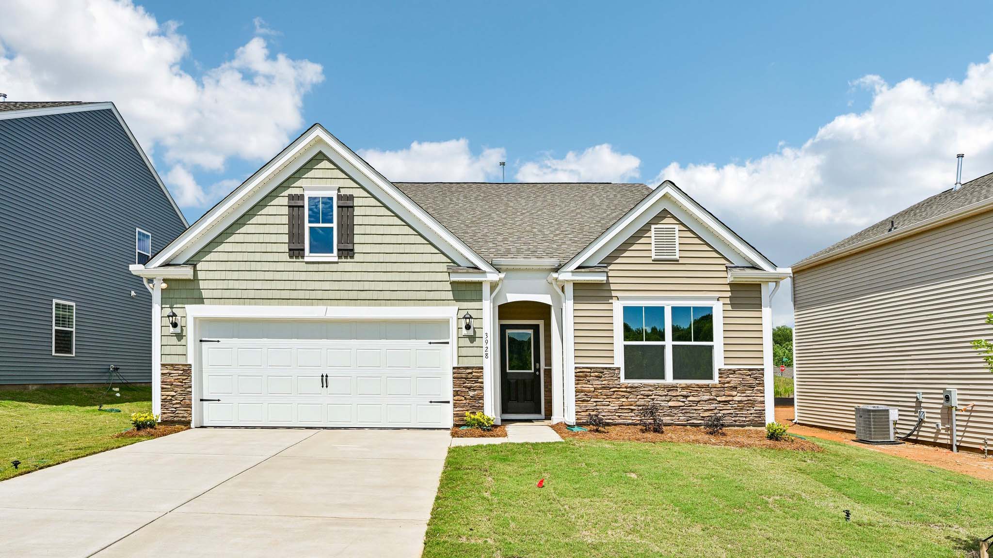 Aria front exterior with brown and white siding, stone and two car garage