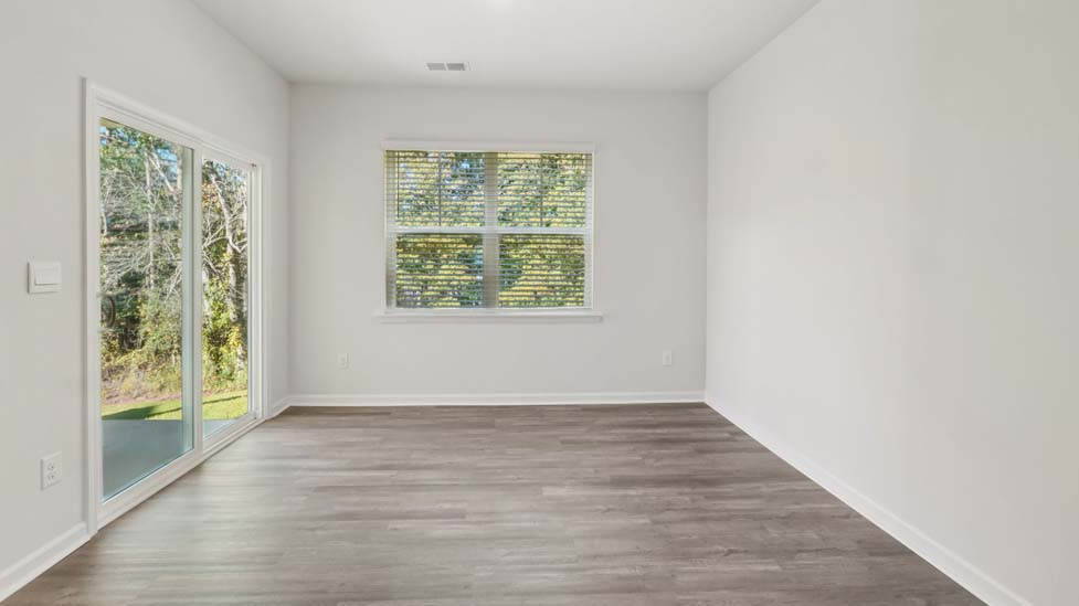 Dining room with wood floors, large window and sliding glass back door