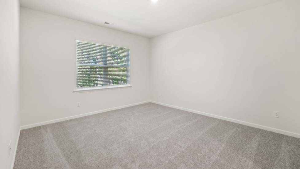 Carpeted bedroom with large window