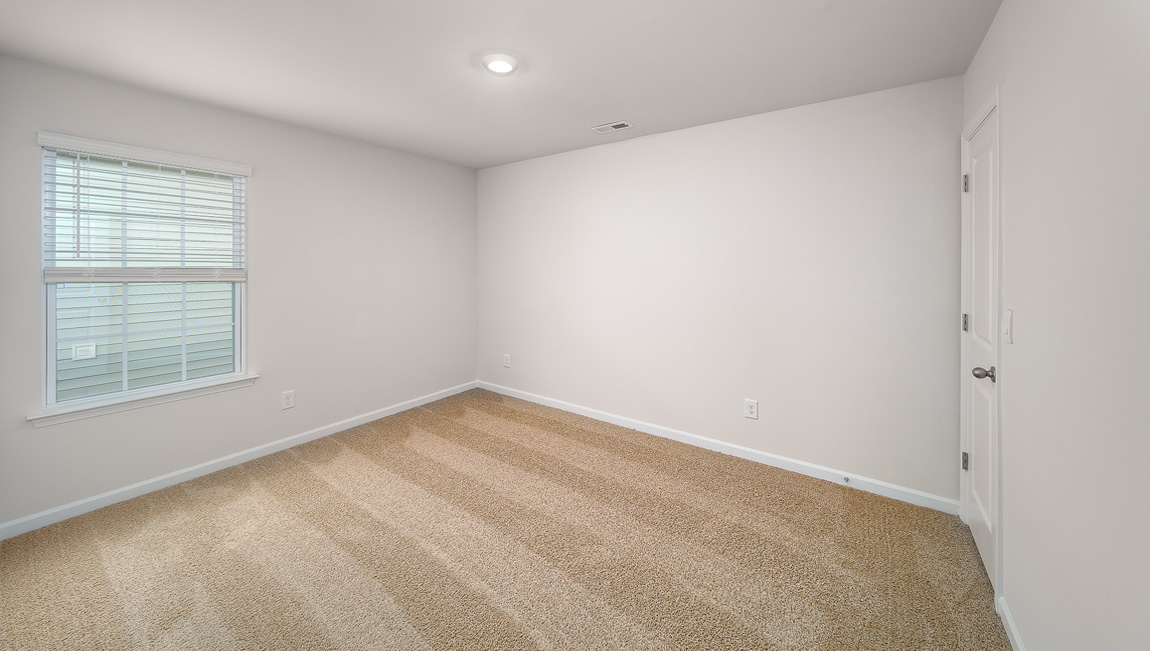 Carpeted bedroom with large window