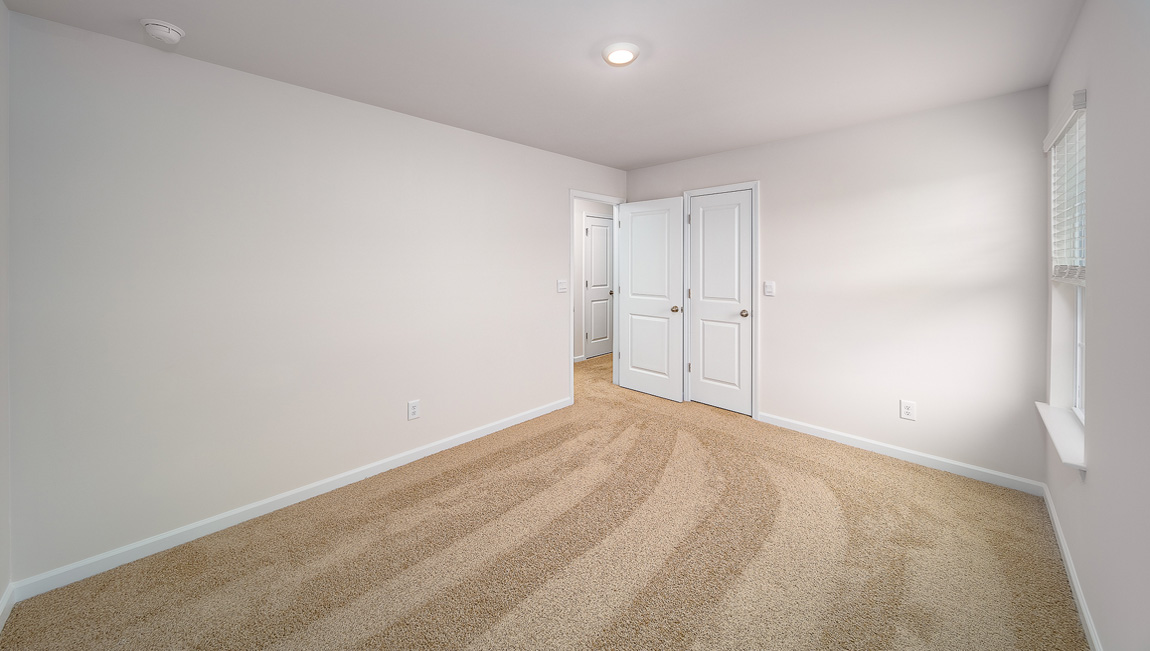 Carpeted bedroom with large window