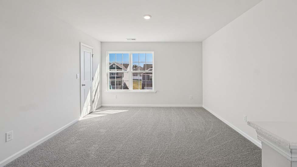 Upstairs carpeted loft with large window