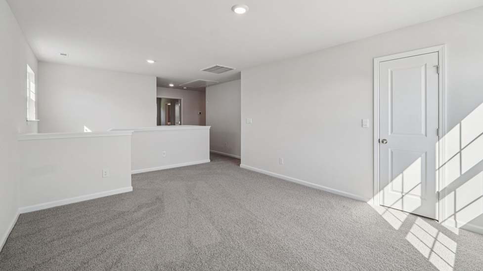 Upstairs carpeted loft with large window
