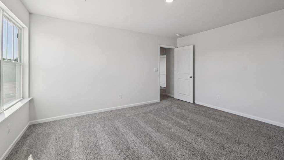 Carpeted bedroom with large windows