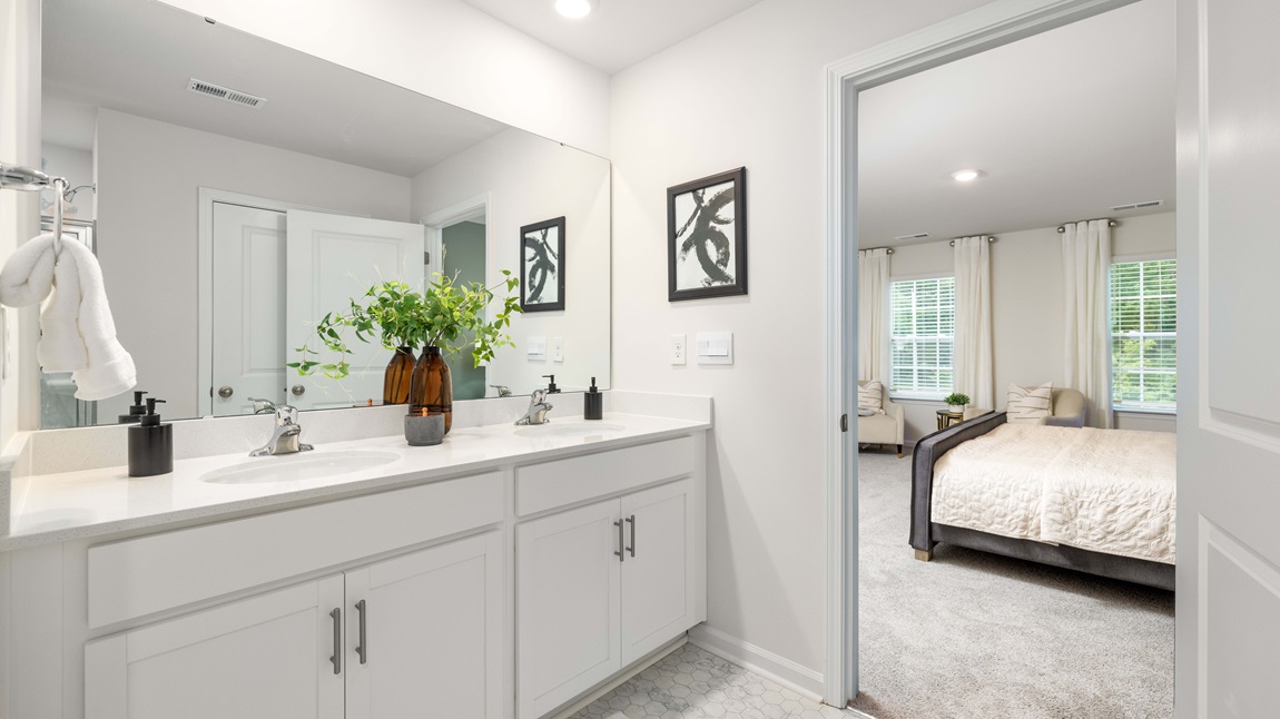 primary bath with double sink vanity and large shower