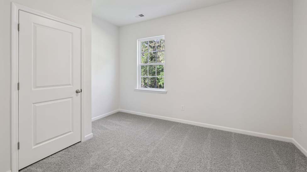 carpeted bedroom with small window