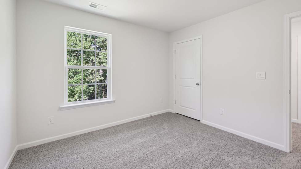 carpeted bedroom with small window