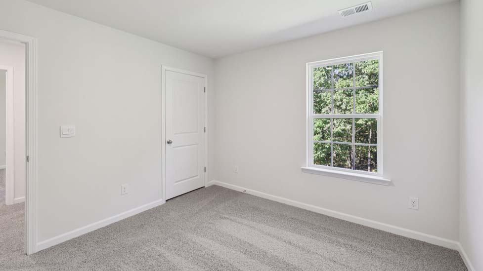 carpeted bedroom with small window
