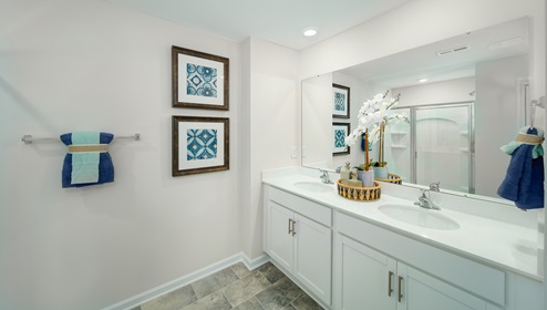 Primary bathroom with double sinks, white counters and cabinets