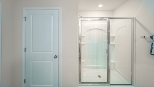 Primary bathroom standing glass door shower and linen closet
