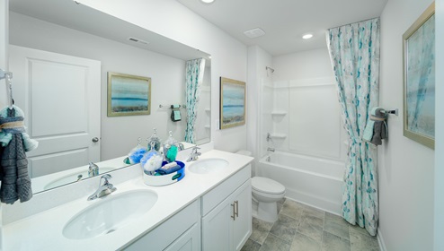 Bathroom with white counters and cabinets, and bathtub