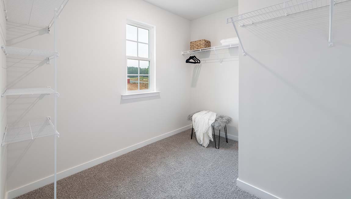 Carpeted primary walk in closet