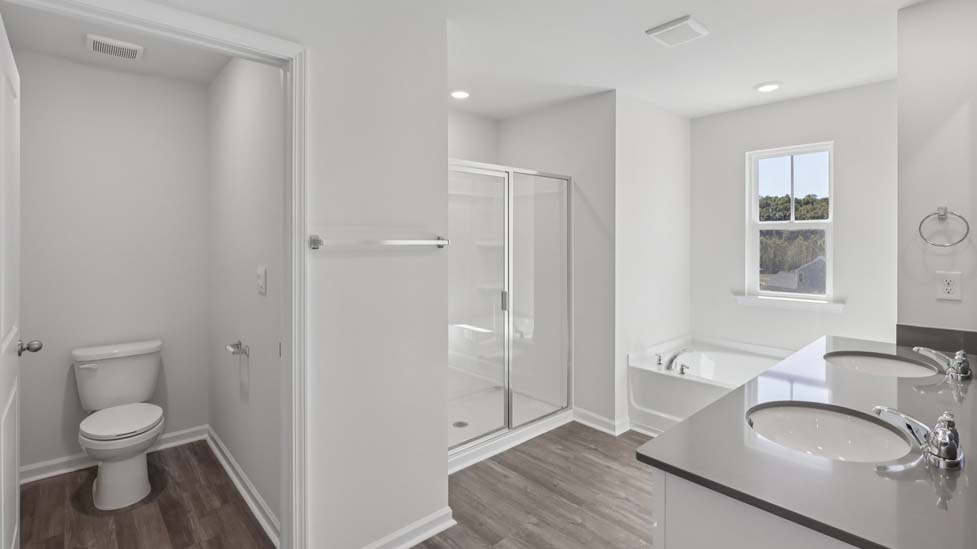 Primary bathroom with double sink vanity, large bathtub, and separate shower