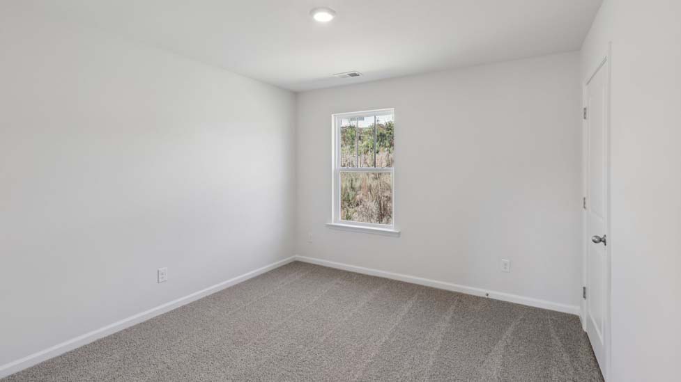 Carpeted bedroom with small window