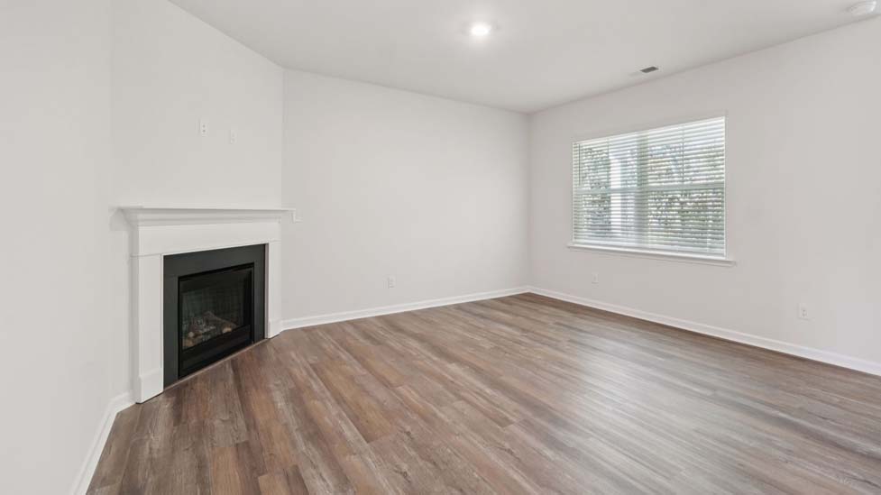 Open concept living roo with fireplace and large windows