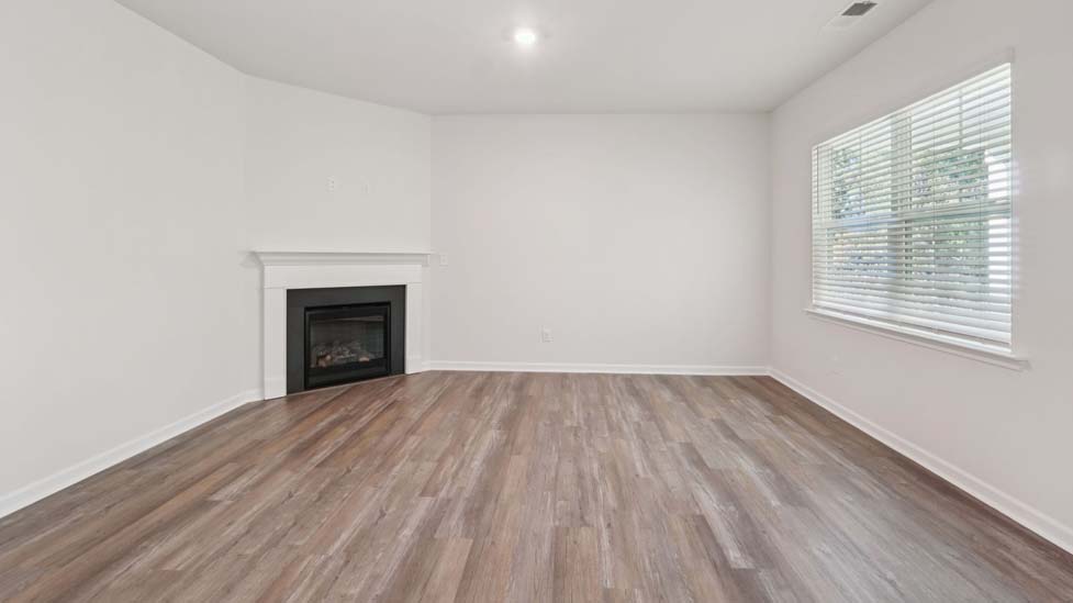 Open concept living roo with fireplace and large windows