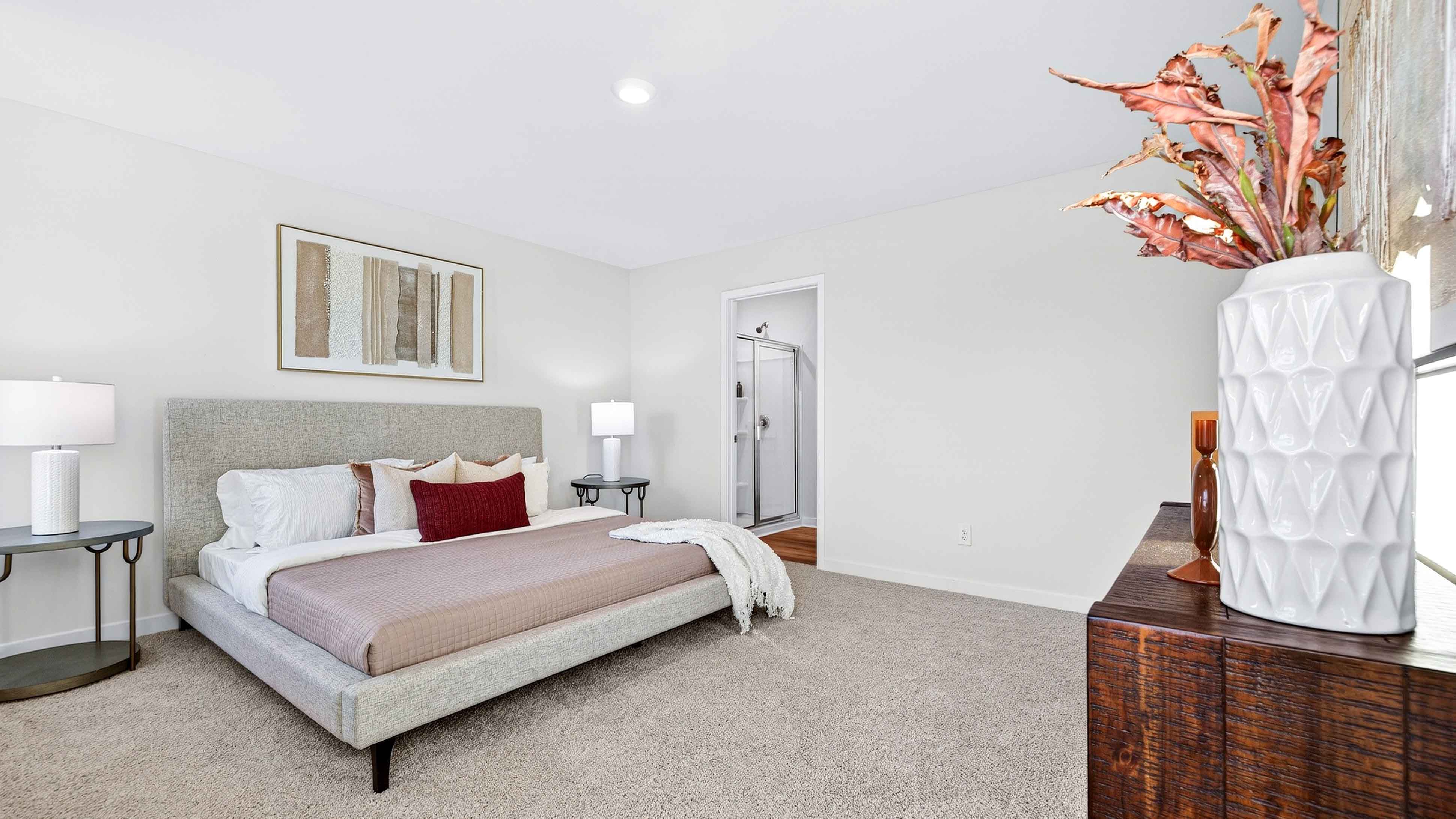 Carpeted primary bathroom with windows