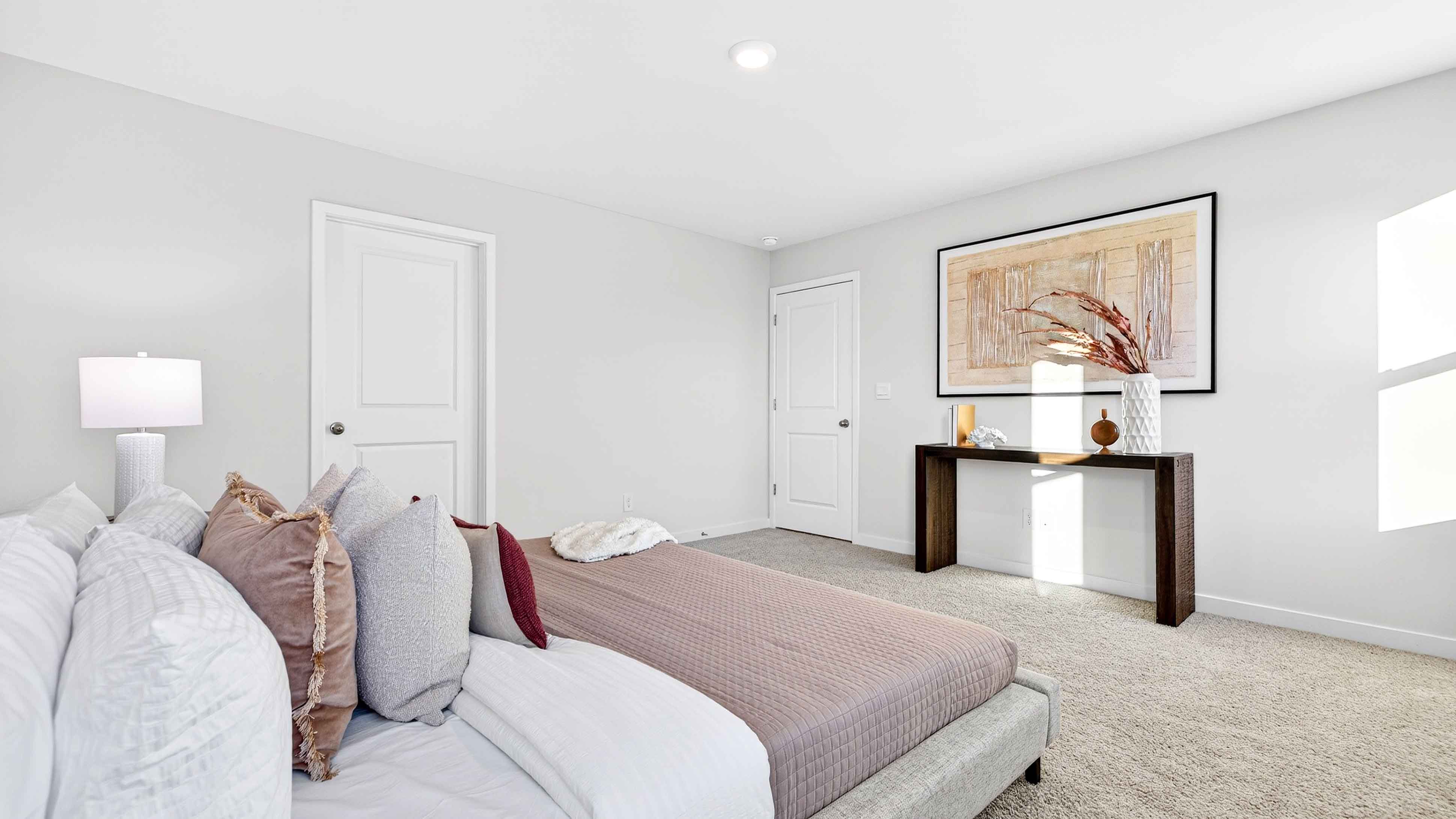 Carpeted primary bathroom with windows